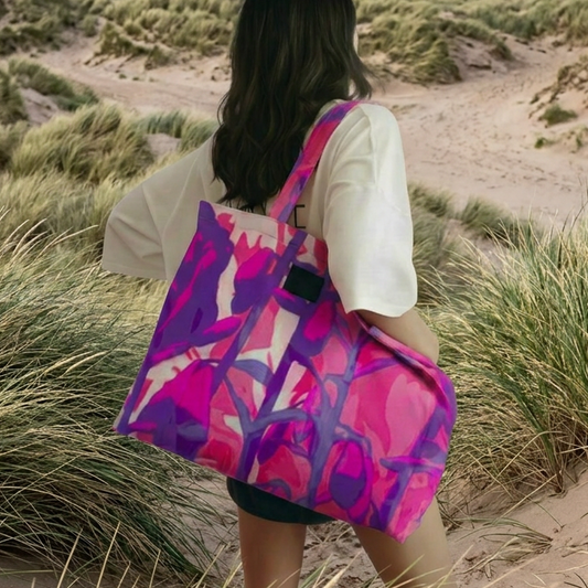 Person walking on a sandy dune with a colorful tote bag