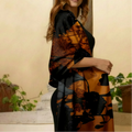 Woman wearing a black and orange patterned scarf in an outdoor setting